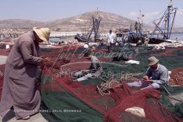 Image du Maroc Professionnelle de  Quelques ouvriers s'activent à réparer les filets de pêche sur un des quais au port d'Agadir, ville située au sud du Maroc, Vendredi 23 Août 2002. (Photo / Abdeljalil Bounhar)

 